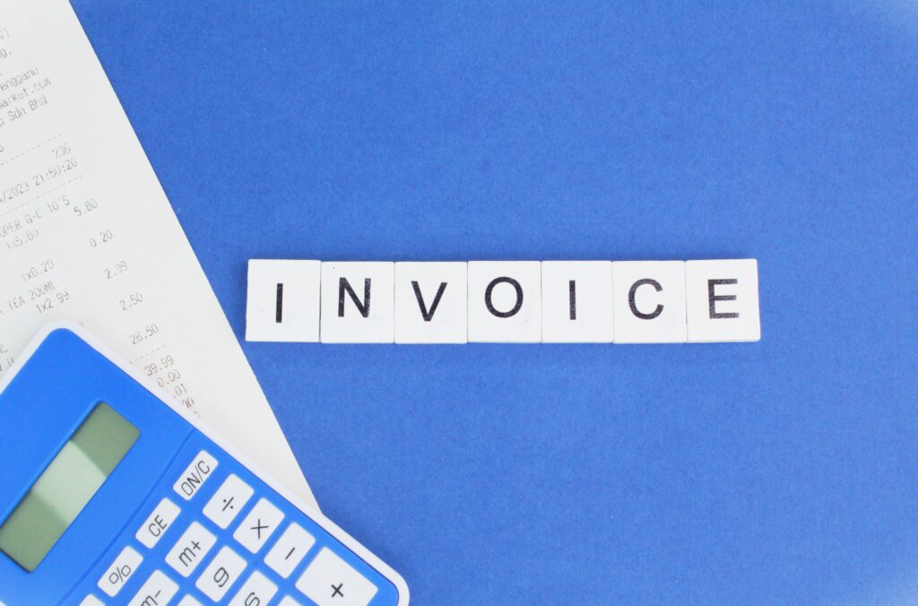 calculator and receipt with the word invoice.